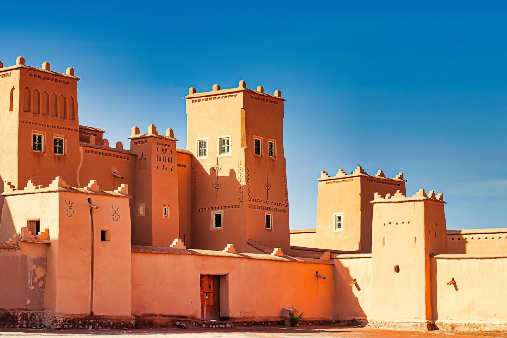 A stunning view of a traditional Moroccan fortress with distinct architectural features against a bright blue sky.